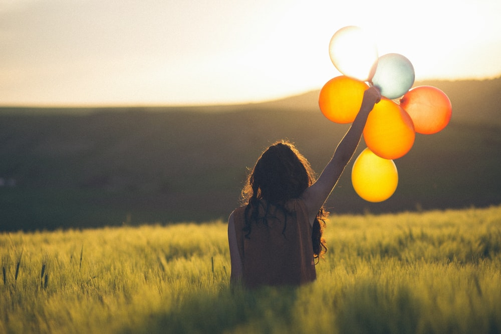 A happy person holding balloons